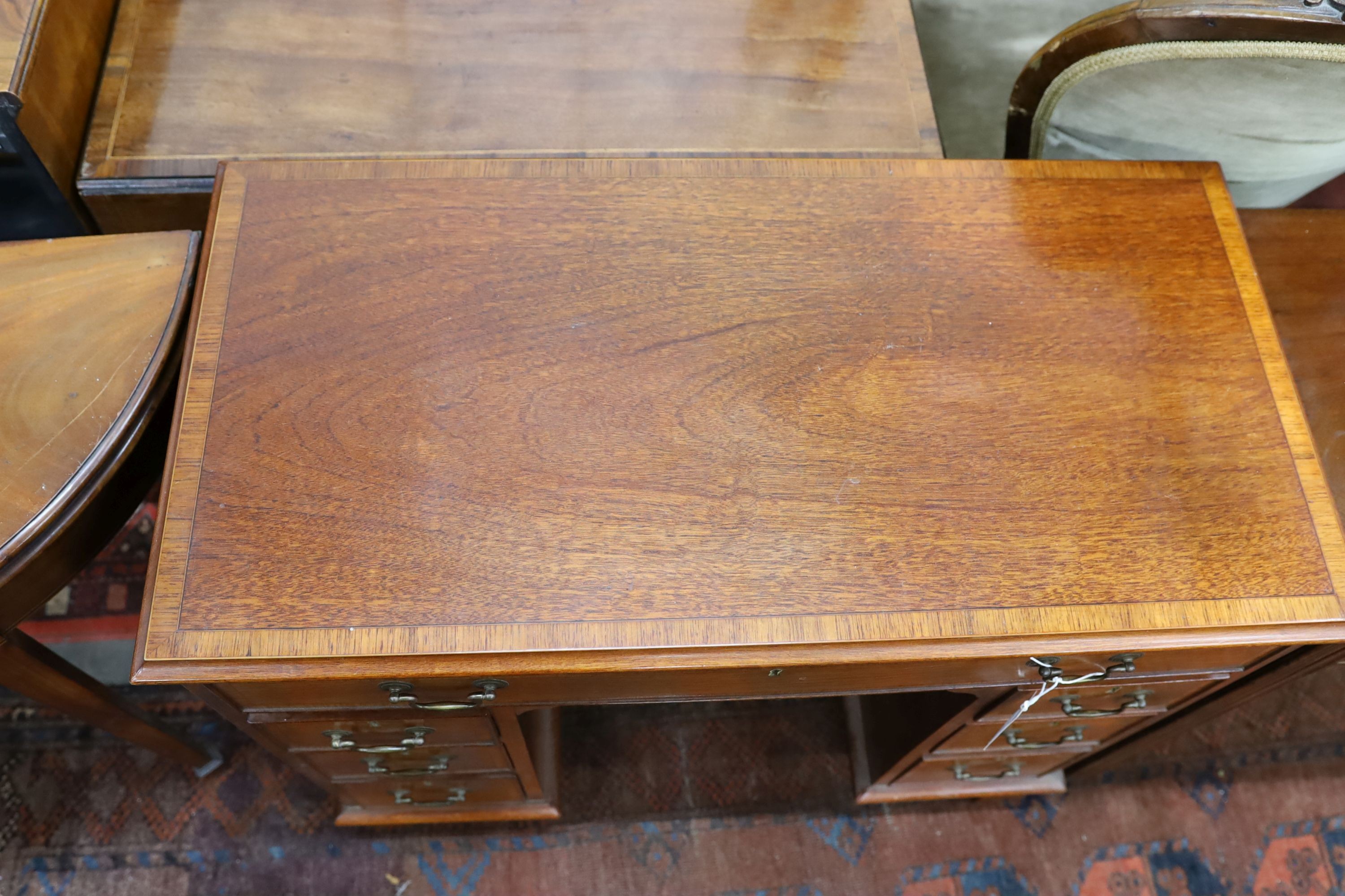 A reproduction George III style rosewood banded mahogany kneehole desk, length 88cm, depth 44cm, height 77cm